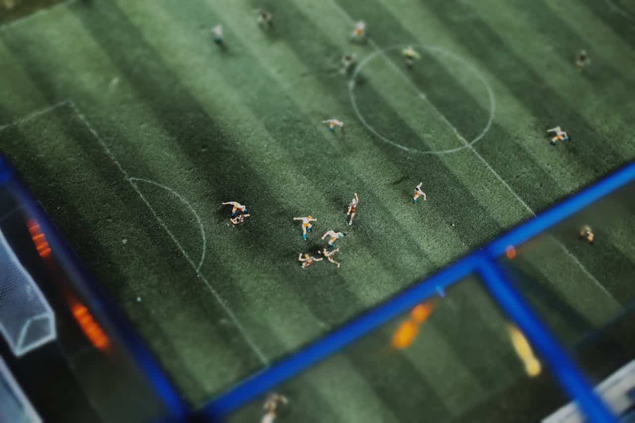 Partita di calcio in miniatura con piccole statuine su un campo da calcio